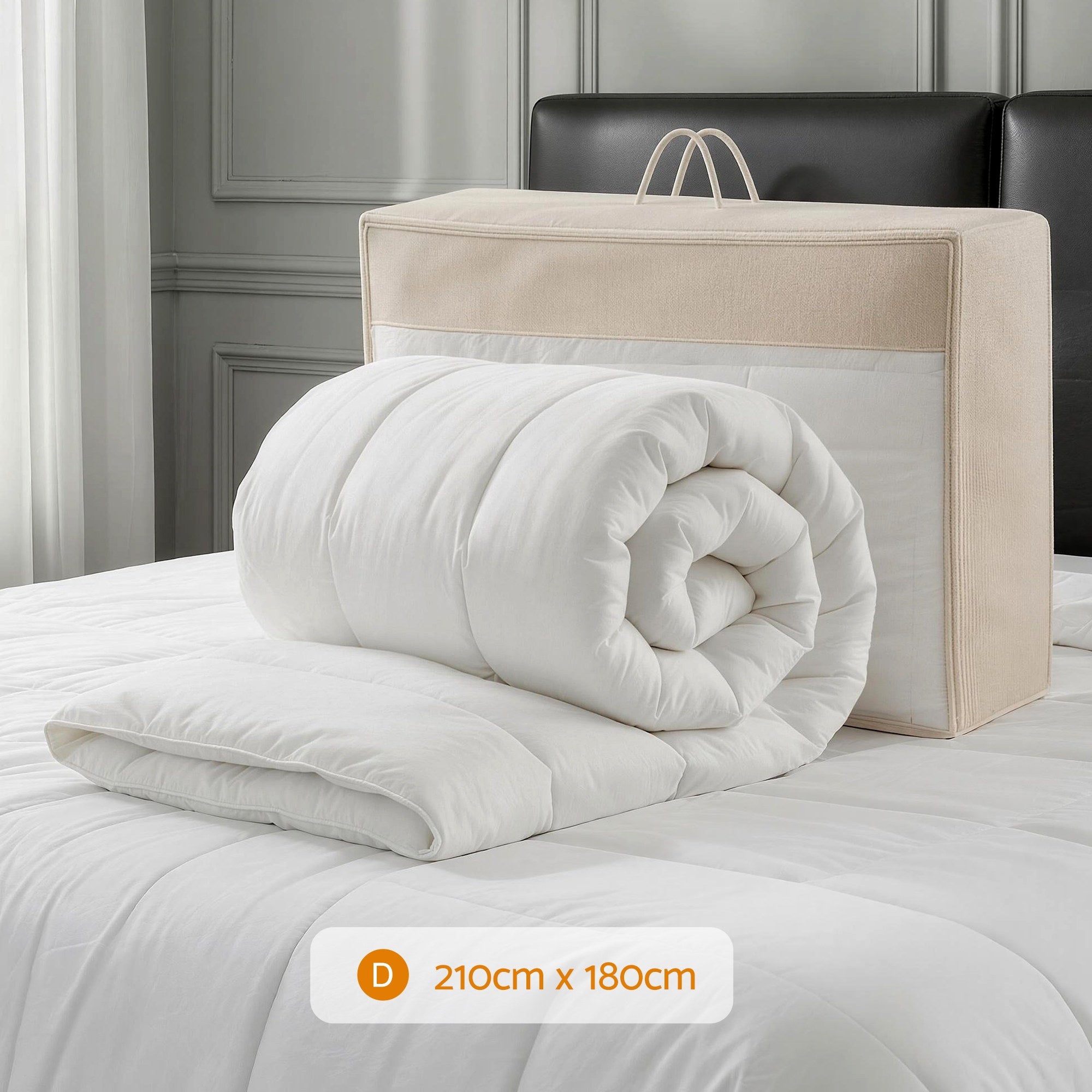 Folded white comforter with beige carrying bag on a bed