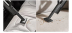 Vacuum cleaning a car seat with debris being collected.