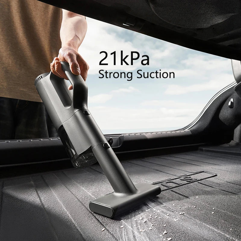 Person using a handheld vacuum cleaner in a car with '21kPa Strong Suction' text displayed.