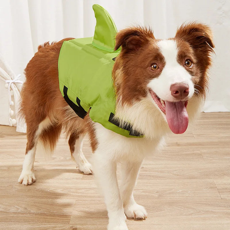 Dog wearing a green shark costume on a wooden floor