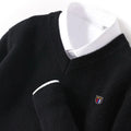 Black sweater with a small logo on a mannequin against a white background