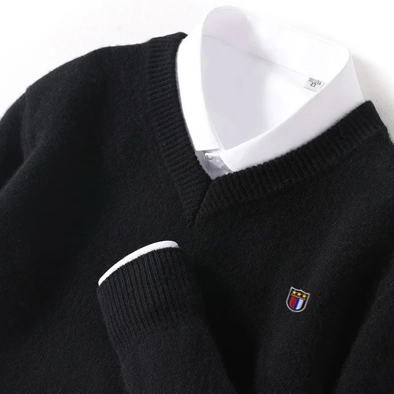 Black sweater with a small logo on a mannequin against a white background