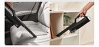 Vacuum cleaning a car seat and a shelf with a handheld vacuum cleaner.