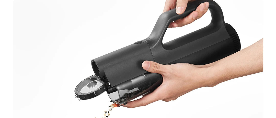 Hand holding a black handheld device with a cutting mechanism on a white background