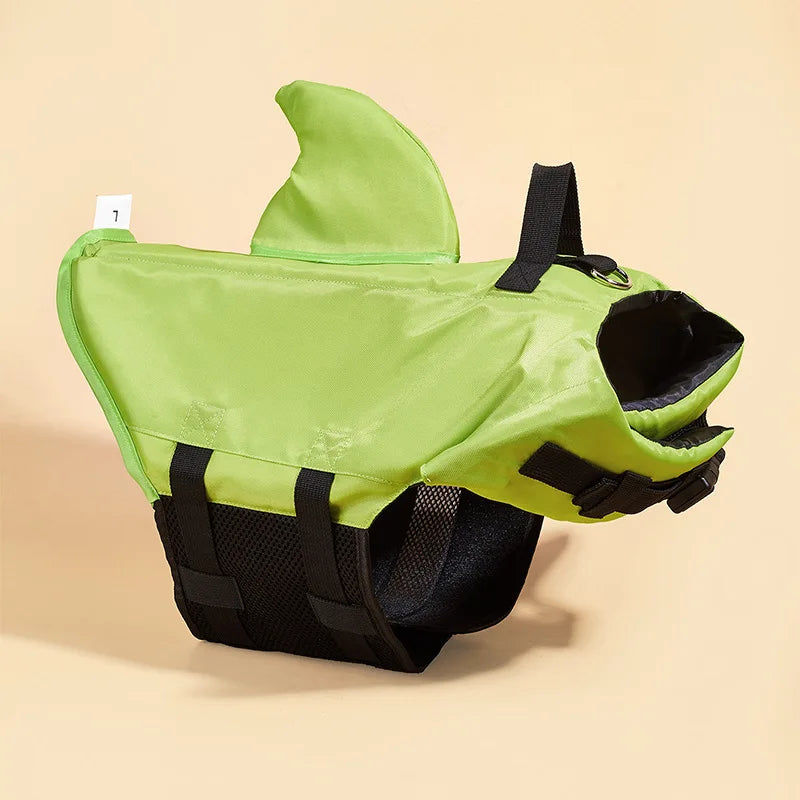 Green shark-shaped dog life jacket on a beige background

Deta