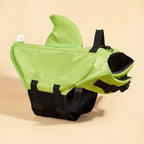 Green shark-shaped dog life jacket on a beige background

Deta