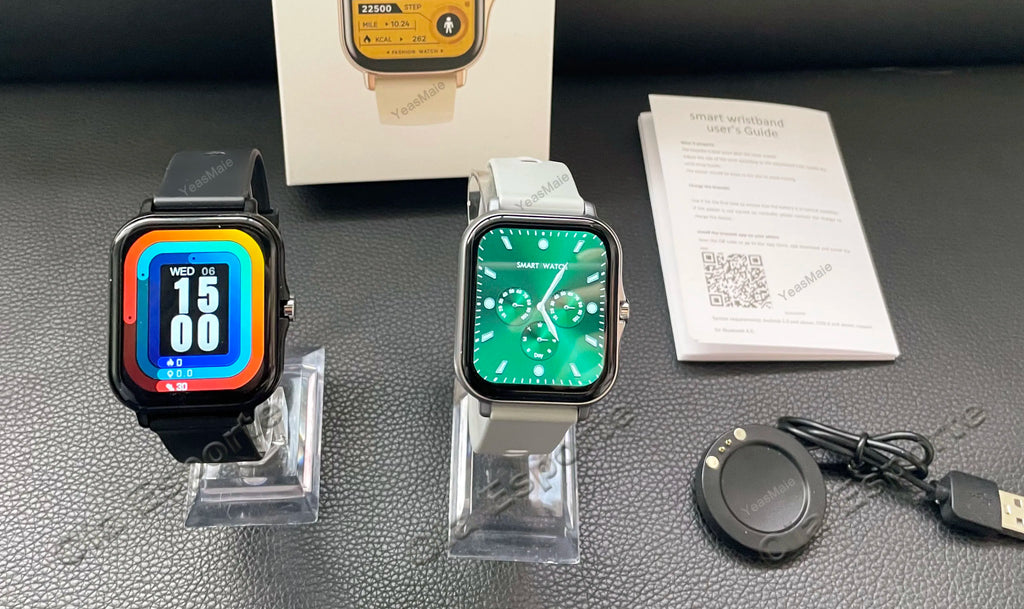 Two smartwatches on stands with a box and cable on a gray surface