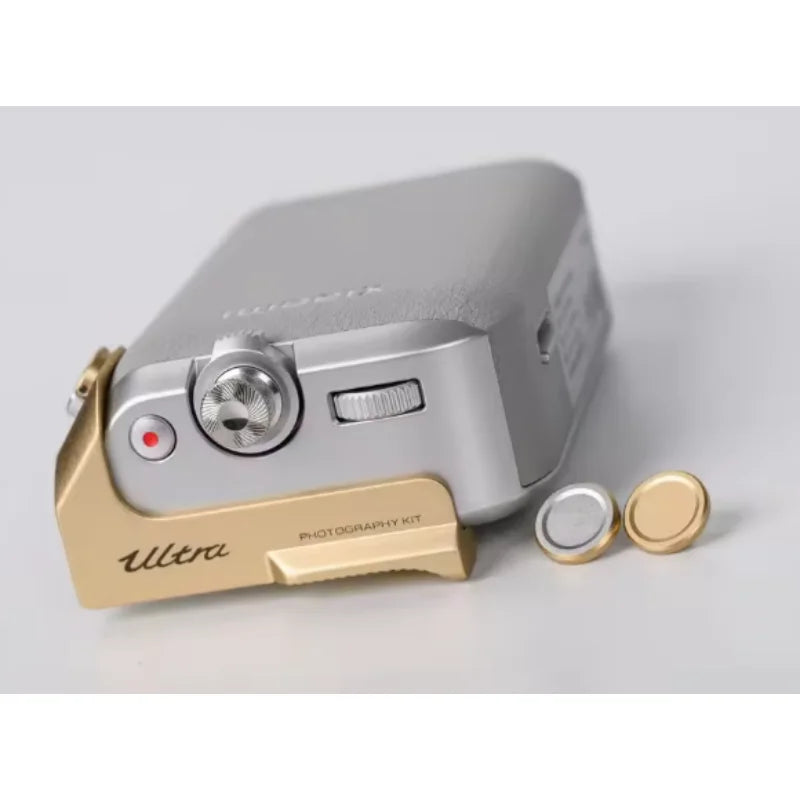 Small electronic device with gold and silver accents on a light gray background