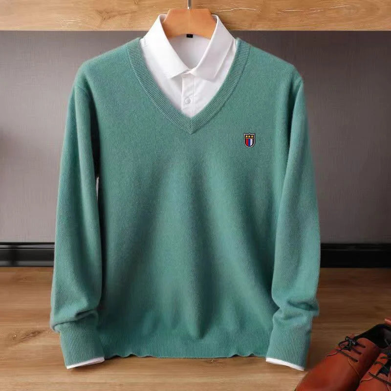 Green sweater with a small logo on a wooden surface