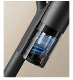 Close-up of a black handheld vacuum cleaner on a beige background