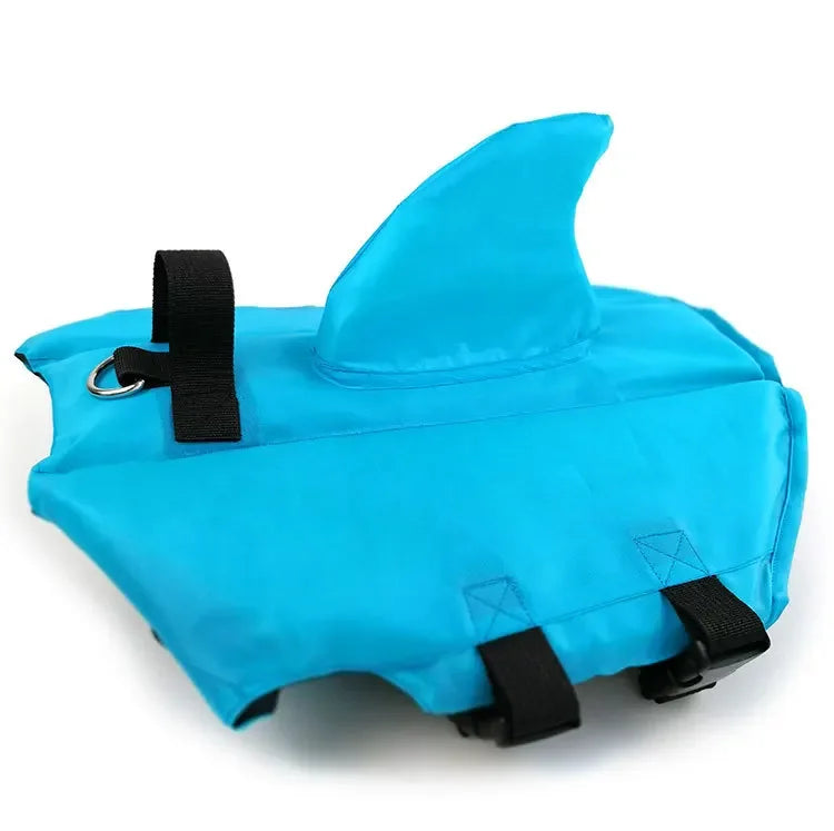 Blue dog life jacket with shark fin design on a white background