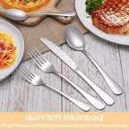 Set of silver cutlery including forks, knives, and spoons on a wooden table with plates of food in the background.