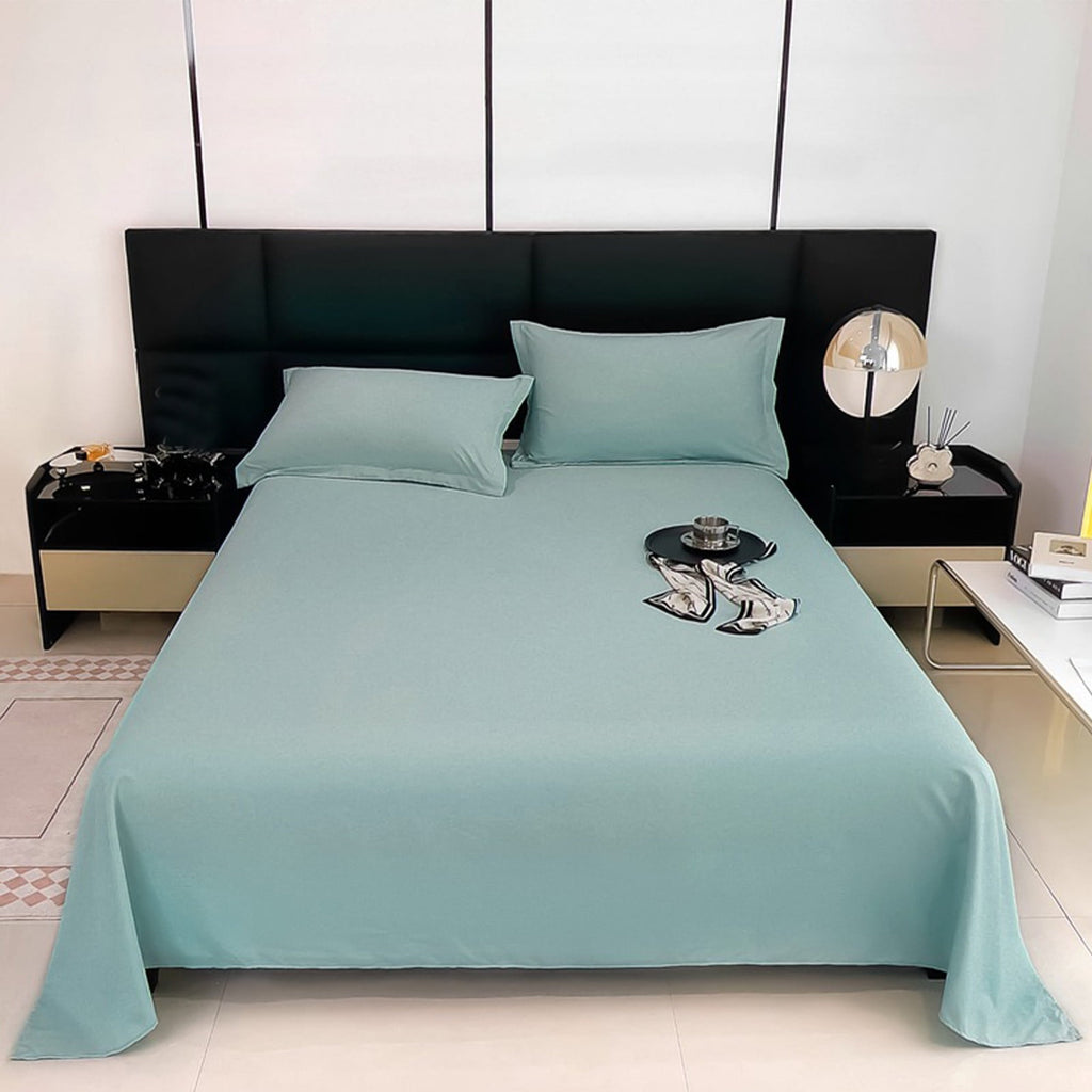 Teal bedspread on a bed with matching pillows in a modern bedroom.