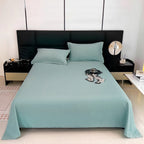 Teal bedspread on a bed with matching pillows in a modern bedroom.