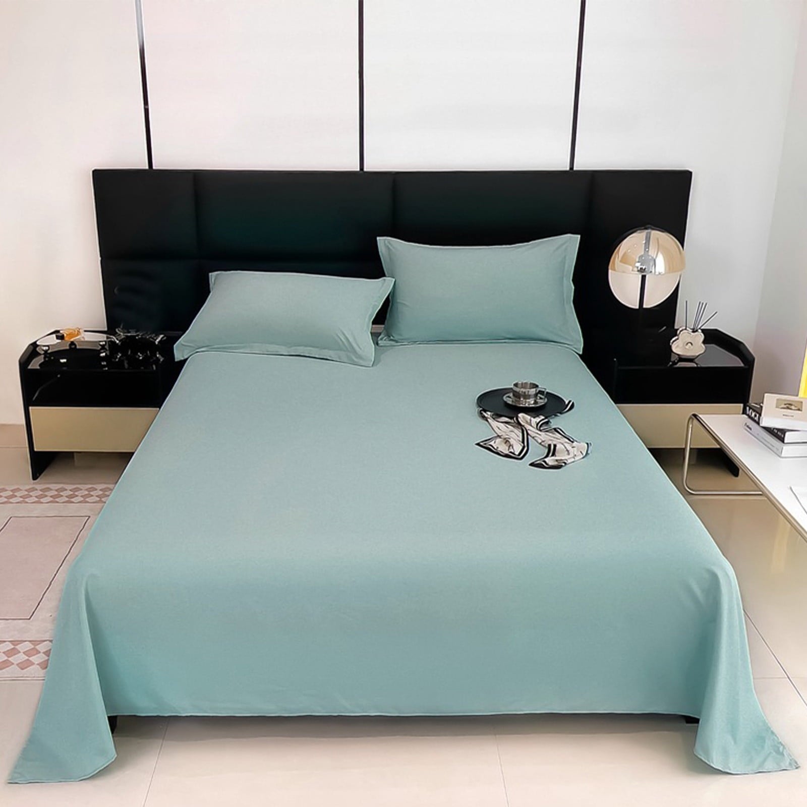 Teal bedspread on a bed with matching pillows in a modern bedroom.