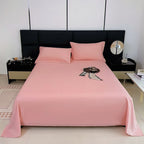 Pink bedspread on a bed with matching pillows in a modern bedroom setting.