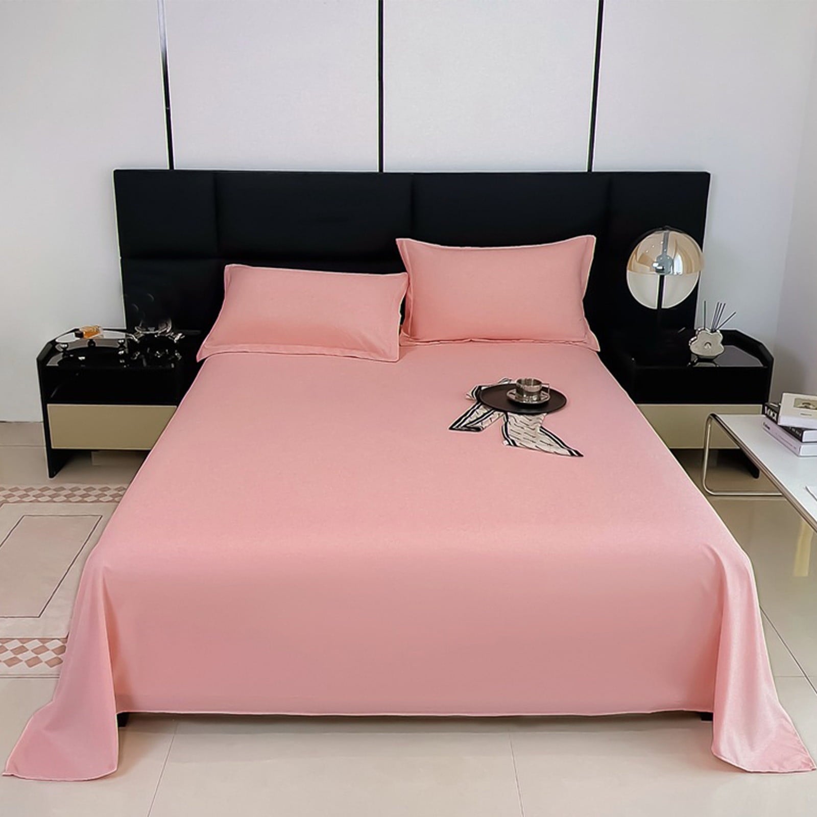 Pink bedspread on a bed with matching pillows in a modern bedroom setting.