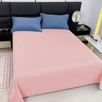 ed with pink fitted sheet and blue pillows in a bedroom setting.