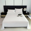 Modern bedroom with a black headboard and white bedding
