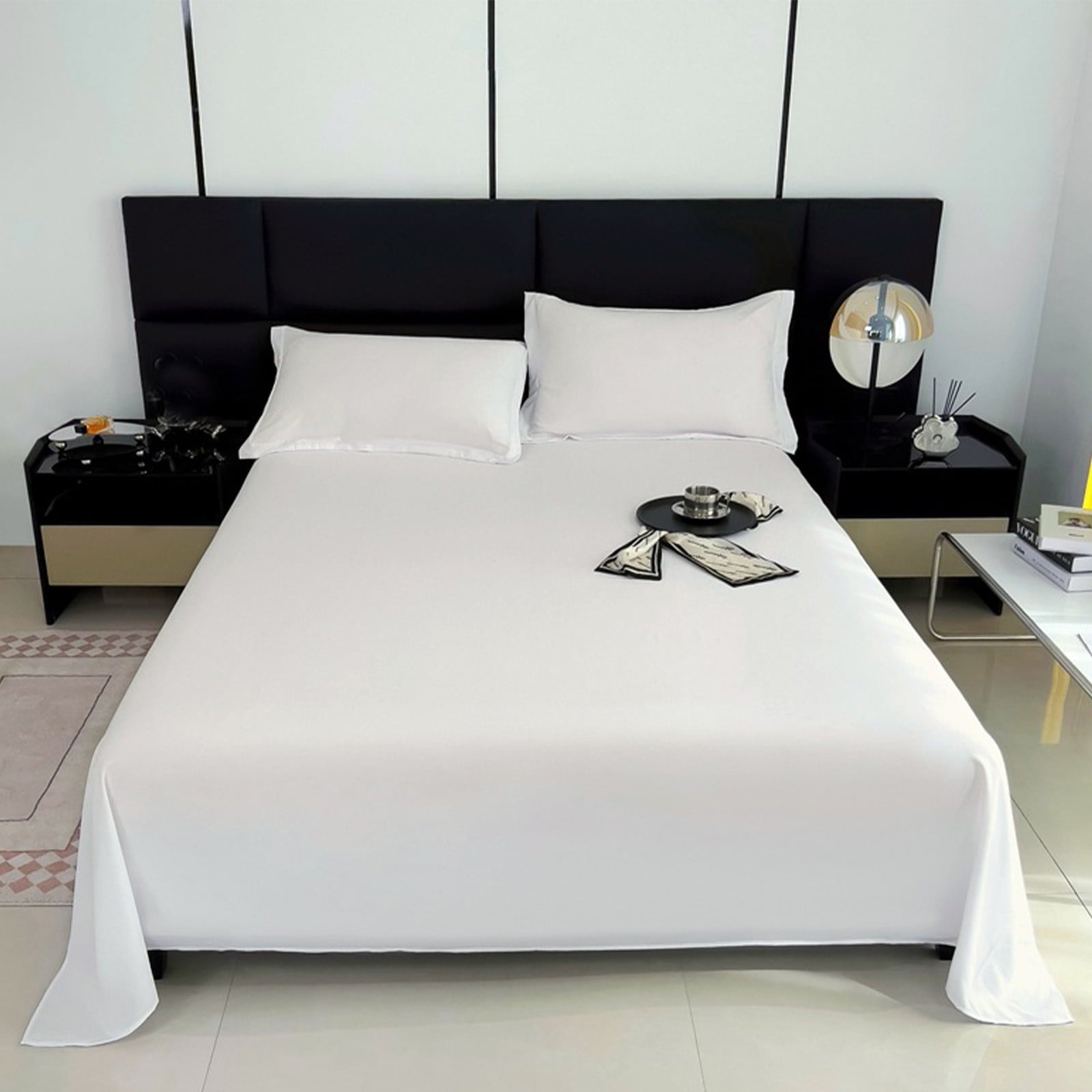 Modern bedroom with a black headboard and white bedding