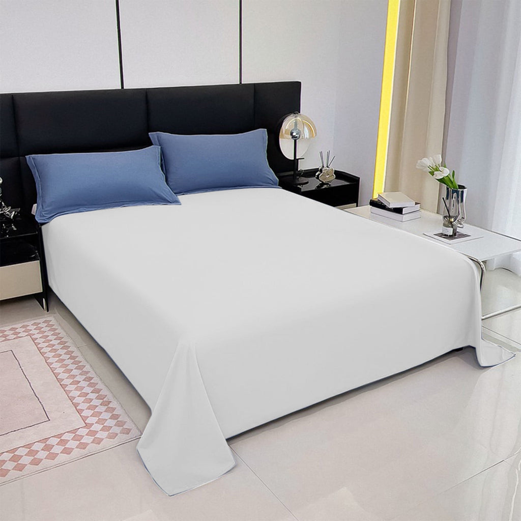 Modern bedroom with a bed featuring blue pillows and white bedding.