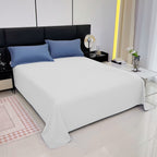 Modern bedroom with a bed featuring blue pillows and white bedding.