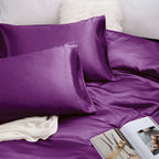 Purple satin pillowcases and bedding on a bed with a magazine.